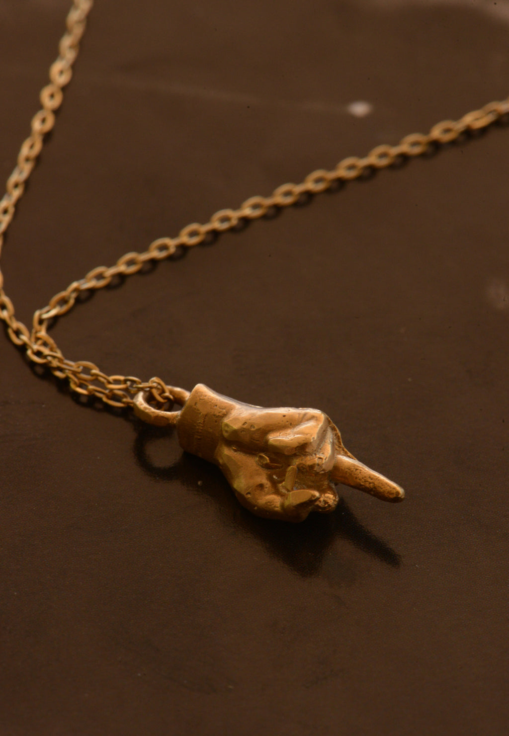 Hand-cast middle finger pendant in gold
