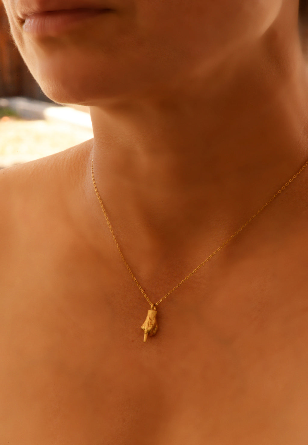 Hand-cast middle finger pendant in gold